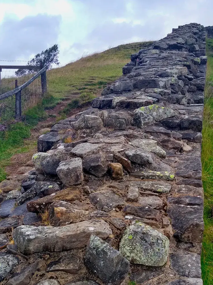 Surviving stone courses of Hadrian’s Wall following a rocky ridge east of Walltown Quarry in Northumberland.