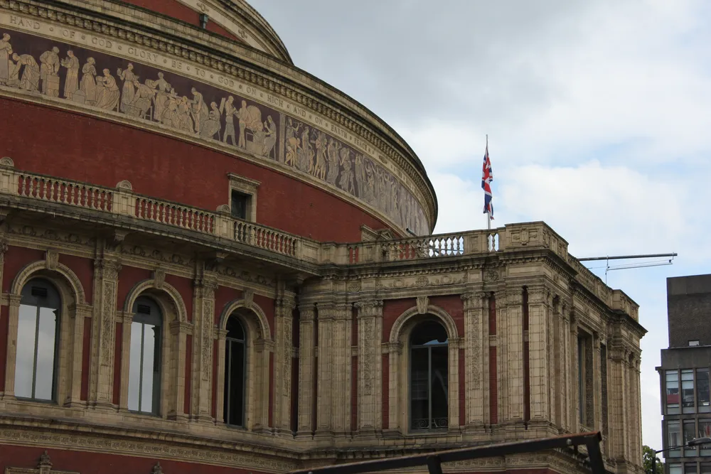 The curved red-brick façade, decorative frieze and stone entrance porch of the Royal Albert Hall in London.